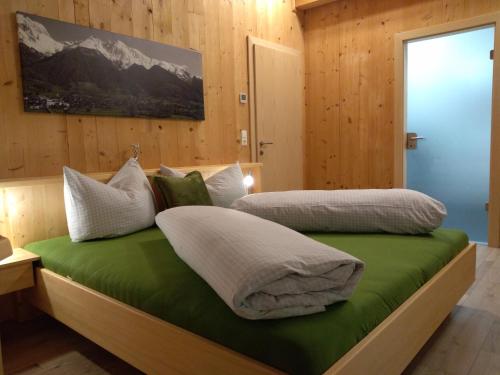 a bedroom with two beds with green and white pillows at Oberrollerhof in Virgen