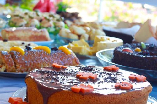 a table with different types of cakes and other desserts at Hotel BHS in Linhares