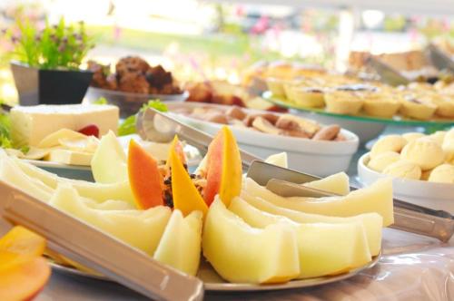 a plate of cheese and fruit on a table at Hotel BHS in Linhares