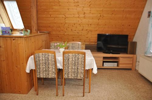 a dining room with a table and a television at Ferienwohnung Neubert in Wolkenstein