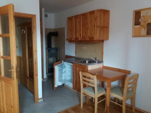 a kitchen with a sink and a table with chairs at Penzion Ve Staré škole in Vlastějovice