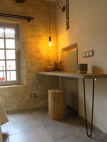 une table dans une pièce avec un mur en pierre dans l'établissement La Taverne de l'Escuelle, à Saint-Guilhem-le-Désert