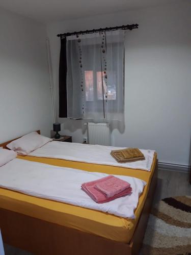 a bedroom with a bed with two towels on it at Erőss Kulcsosház in Lăzarea