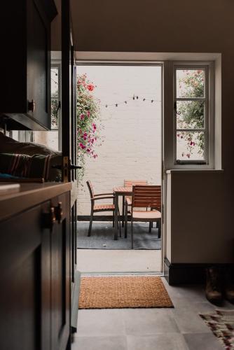 a kitchen with a door open to a patio with a table at Penny Black Cottage in Coalbrookdale