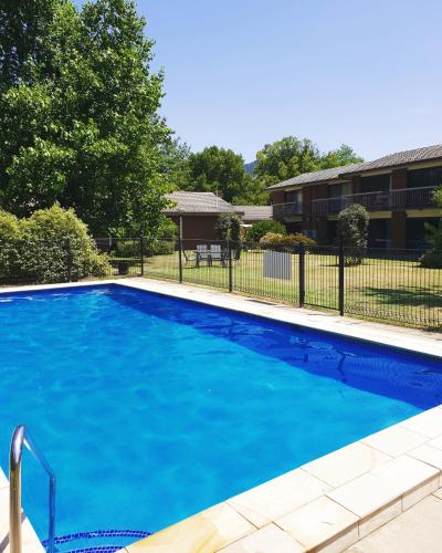 a large blue swimming pool in front of a building at Motel Sierra - Bright in Bright