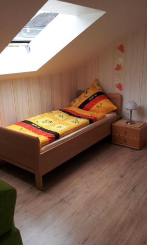 a bed sitting in a room with a skylight at Appartement Ferienwohnung Vogel in Hilchenbach