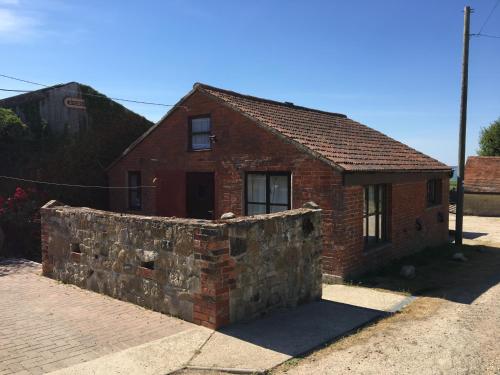 a brick house with a stone wall in front of it at New Stable Cottage in Cowes