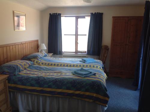 a bedroom with two beds and a window at New Stable Cottage in Cowes