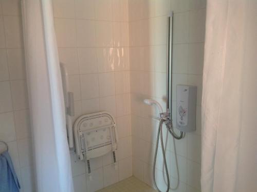 a bathroom with a shower with a sink and a shower at New Stable Cottage in Cowes