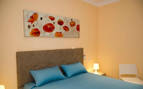 een slaapkamer met een blauw bed en een schilderij erboven bij Sliema duplex 1 bedroom apartment - Sleeps 4 in Sliema
