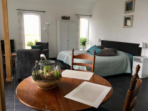 a living room with a table and a bedroom at De Borg Vakantie Appartementen in Winterswijk