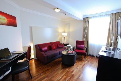 a living room with a red couch and a table at Holzapfel in Bad Füssing