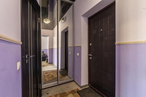 a corridor of a bathroom with purple walls and doors at Apartments for your happiness in Dnipro
