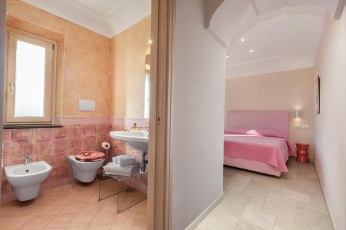 a bathroom with a sink toilet and a bed at Amore Rentals - Residence Bosco in SantʼAgata sui Due Golfi