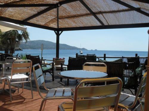 a patio with tables and chairs and a view of the ocean at Casa Del Golfo in Lacona