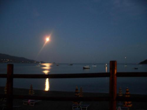 a moon rising over a body of water at night at Casa Del Golfo in Lacona