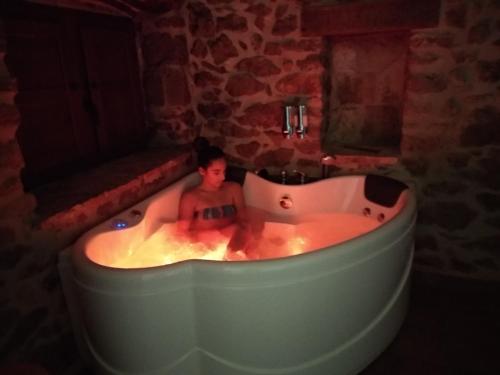 a boy sitting in a bath tub in a room at Aldea Ecorural in Vilar de Canes