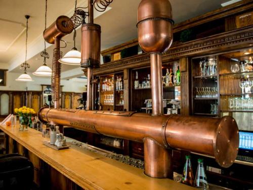 a bar with a large copper pipe on the counter at Alter Wirt Thalkirchen in Munich