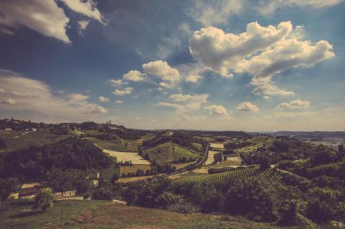 a view of a valley with a river and clouds at Agriturismo I Surì Asti in Asti