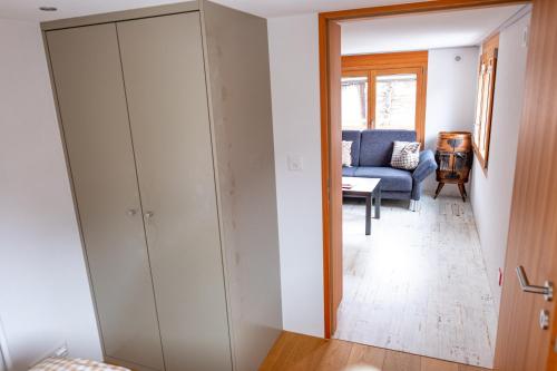 a living room with a large closet and a blue couch at Appartement Binna in Termen