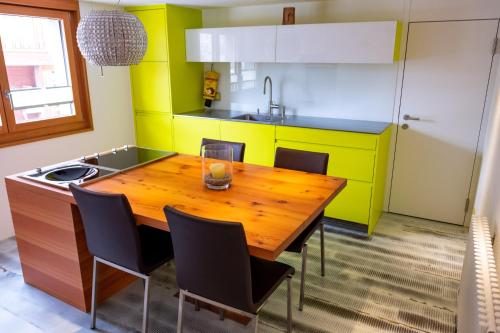 a kitchen with a wooden table and chairs at Appartement Binna in Termen