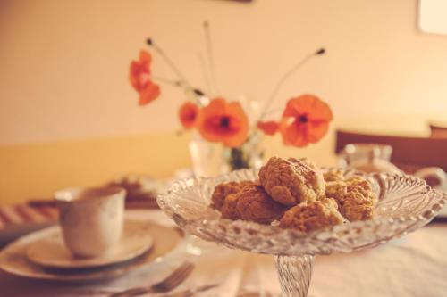 a plate of food on a table with a cup and flowers at Agriturismo I Surì Asti in Asti