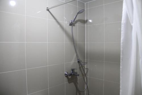 a shower with a shower curtain in a bathroom at Cubao ManhattanHeights Unit 23D Tower C, 1 BR in Manila