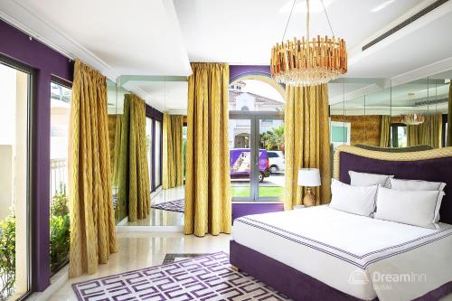 a bedroom with a bed and a chandelier at Dream Inn - Palm Island Retreat Villa in Dubai