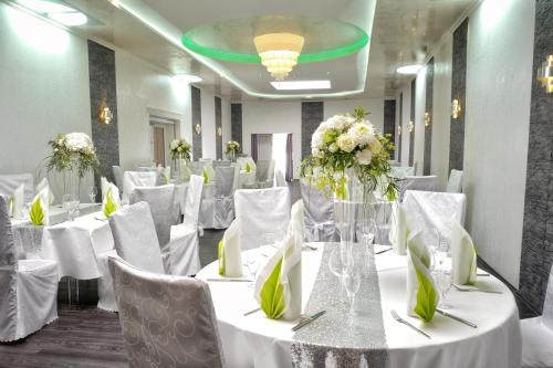 a room with white tables and chairs with flowers on them at Hotel Krone in Friesenheim