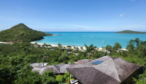 una vista aerea di una spiaggia con barche in acqua di Hermitage Bay - All Inclusive a Saint John's