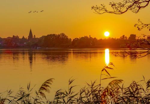a sunset over a lake with the sun setting at Useriner Ferienhaus in Userin