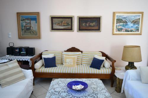 a living room with a couch with blue and white pillows at Villa Marika in Vathi, Ithaka