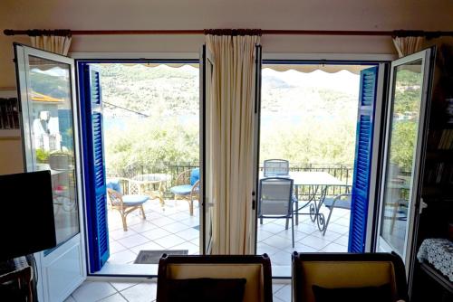 an open door to a patio with a table and chairs at Villa Marika in Vathi, Ithaka