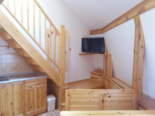 a room with a staircase with a microwave and a television at Penzion Ve Staré škole in Vlastějovice