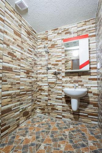 a bathroom with a sink and a shower at Erőss Kulcsosház in Lăzarea