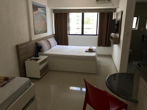 a small bedroom with a bed and a window at Studio Everest Flats in Recife