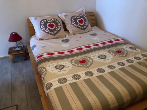 - une chambre avec un lit doté d'un couvre-lit et de coeurs dans l'établissement L’edelweiss, à Villard-sur-Doron