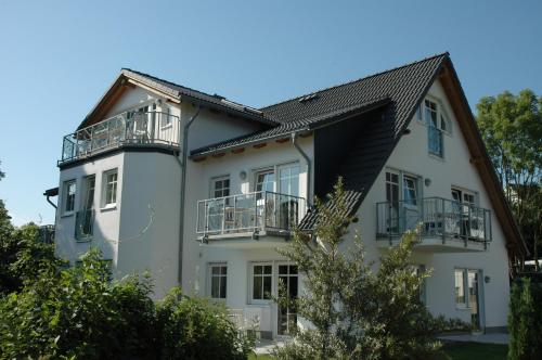 a white house with balconies on the side of it at Dünenhaus in Göhren