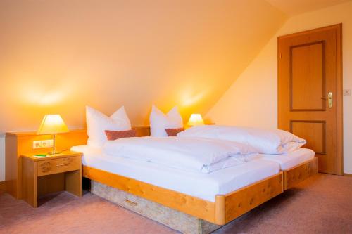 a bedroom with two beds with white pillows at Landhaus Rössle in Schwäbisch Hall