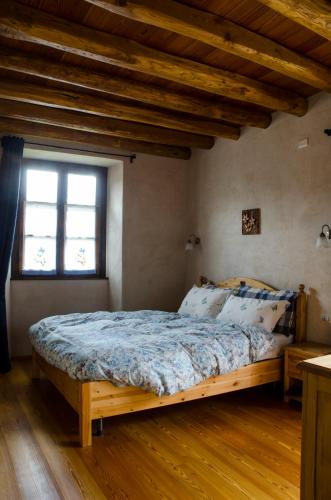 a bedroom with a wooden bed in a room with a window at Agriturismo il posto delle fragole in San Giovanni Bianco