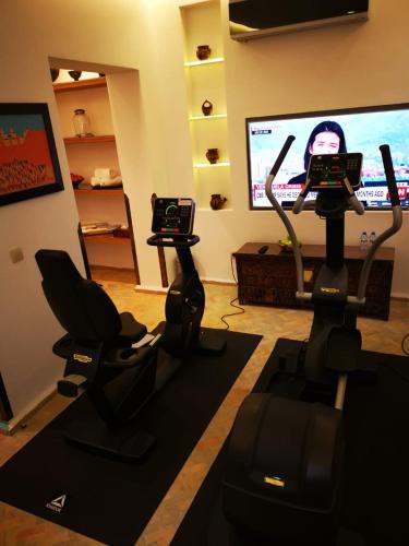 a room with two exercise bikes and a tv at La Maison Arabe Hotel, Spa & Cooking Workshops in Marrakech