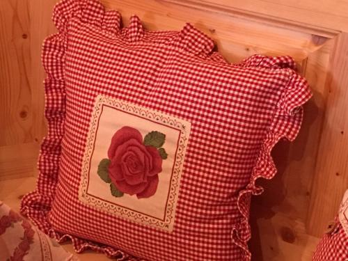 a red and white pillow with a red flower on it at Endweg in Grindelwald