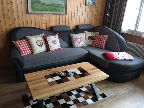 a living room with a blue couch and a coffee table at Endweg in Grindelwald