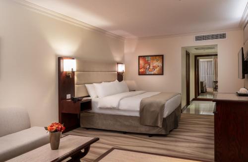 a hotel room with a bed and a couch at Landmark Amman Hotel & Conference Center in Amman