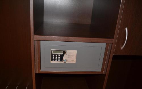a safe with a telephone in a wooden cabinet at Hotel Motel 2 in Castel San Giovanni