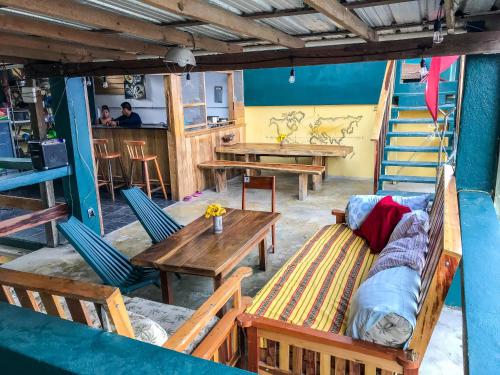 a room with tables and chairs and a couch at Bella's Backpackers Cayo in San Ignacio