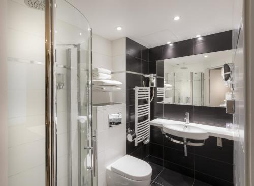 a bathroom with a sink, toilet and shower at Hotel de la Paix Tour Eiffel in Paris