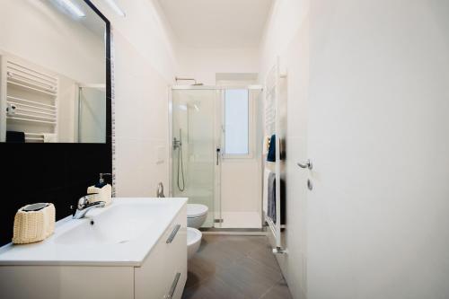 a white bathroom with a sink and a toilet at La Boutique del Vento - Esclusivo in pieno centro in Trieste