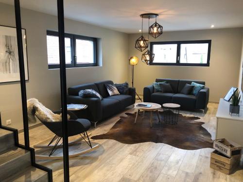 a living room with a couch and a table at Gîte Wellness Le Six H in Andolsheim