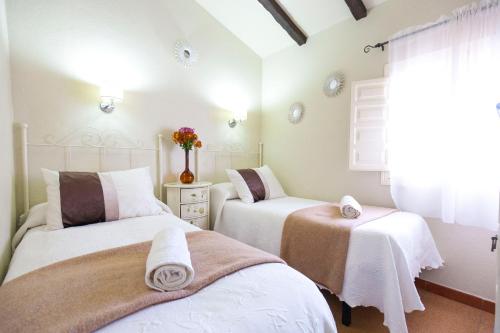 1 dormitorio con 2 camas y toallas. en Hacienda El Molino, en El Bosque